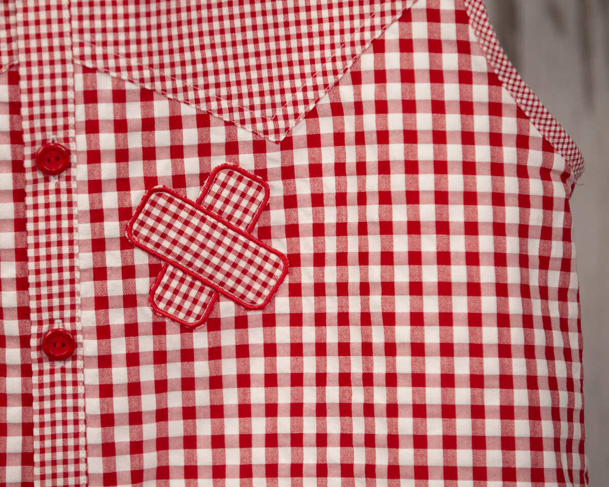 AMANTALA-COWBOY-PLIEGUE-MAESTRO-SIN-MANGAS-VICHY-ROJO-DETALLE-TIRITA